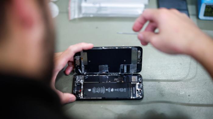 A smartphone repair technician works on a Apple iPhone SE in Saint-Sebastien-sur-Loire, near Nantes, October 7, 2024. REUTERS/Stephane Mahe