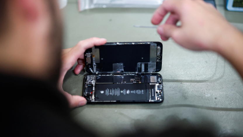 A smartphone repair technician works on a Apple iPhone SE in Saint-Sebastien-sur-Loire, near Nantes, October 7, 2024. REUTERS/Stephane Mahe