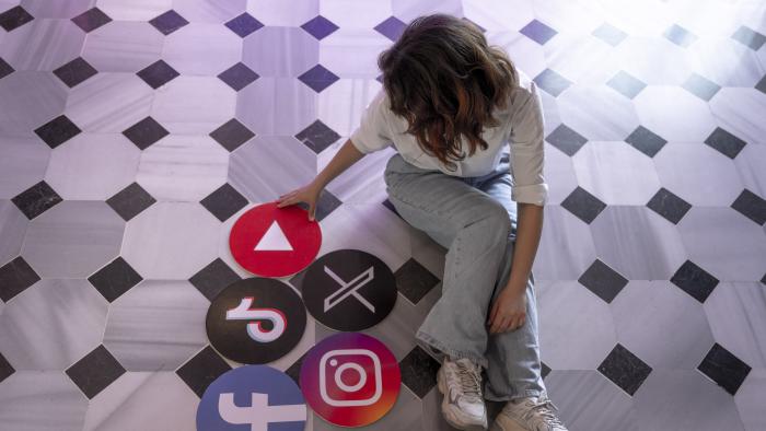 ISTANBUL, TURKIYE - JUNE 08: A woman sits next to the banners of TikTok, Facebook, Youtube, Instagram and X in Istanbul, Turkiye on June 08, 2024. (Photo by Didem Mente/Anadolu via Getty Images)