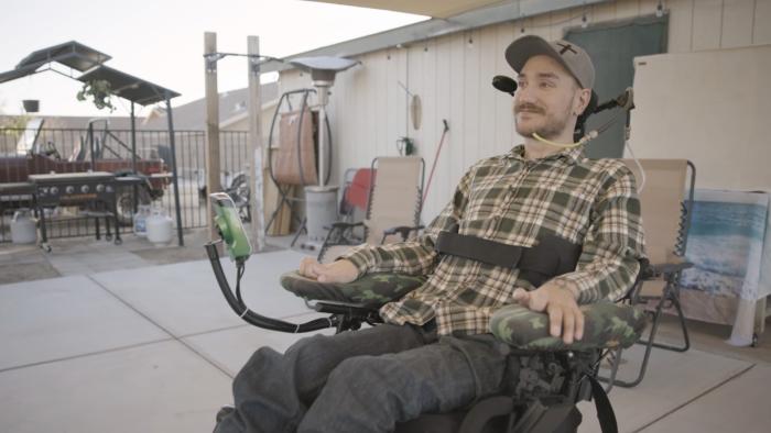 A man strapped to a wheelchair.